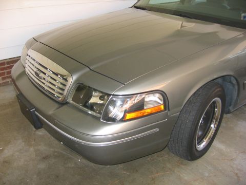 2000 Ford Crown Victoria - Close-up of the front of a silver Ford Crown Victoria, showing the grille and headlight assembly.