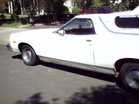 1973 Ford Ranchero - A white coupe utility is parked on the street, with a red vehicle in the background.