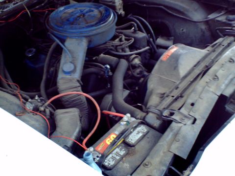 1973 Ford Ranchero - Close-up view of the engine bay of a 1973 Ford Ranchero, showing the air cleaner, battery, and various hoses.