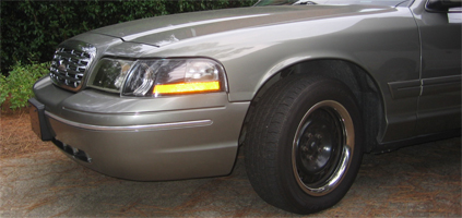 2000 Ford Crown Victoria - Front passenger side of a 2000 Ford Crown Victoria, showing the headlight and wheel.