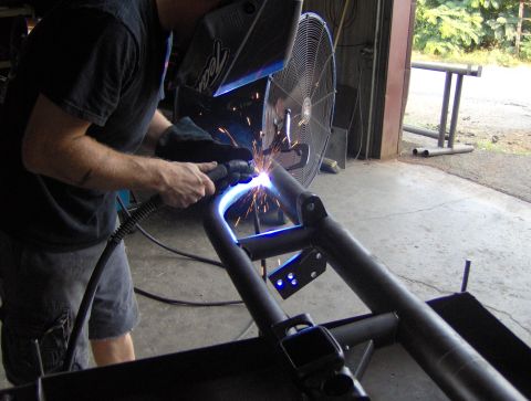 1978 Ford Bronco - Welder fabricates a custom metal frame in a workshop setting.