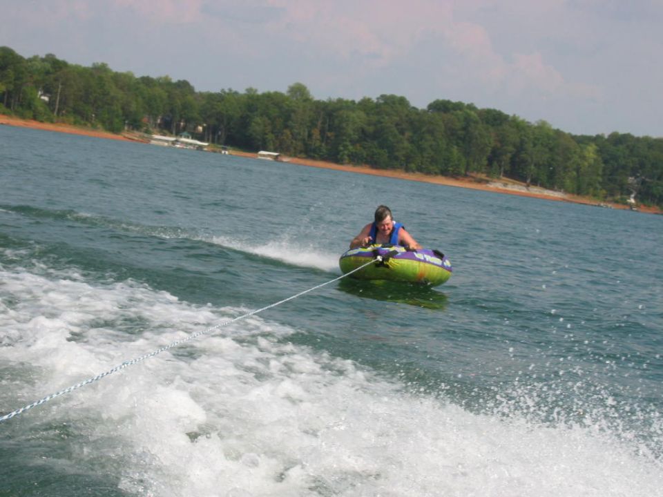 Person tubing on a lake, pulled by a boat