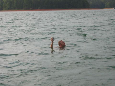 1985 Ford LTD Crown Victoria - A man enjoys a day on Lake Hartwell, SC, holding a can while swimming in the water.