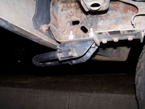 1990 Ford Bronco - Detail of a vehicle's tow hook and frame assembly, showing rust and mounting hardware.