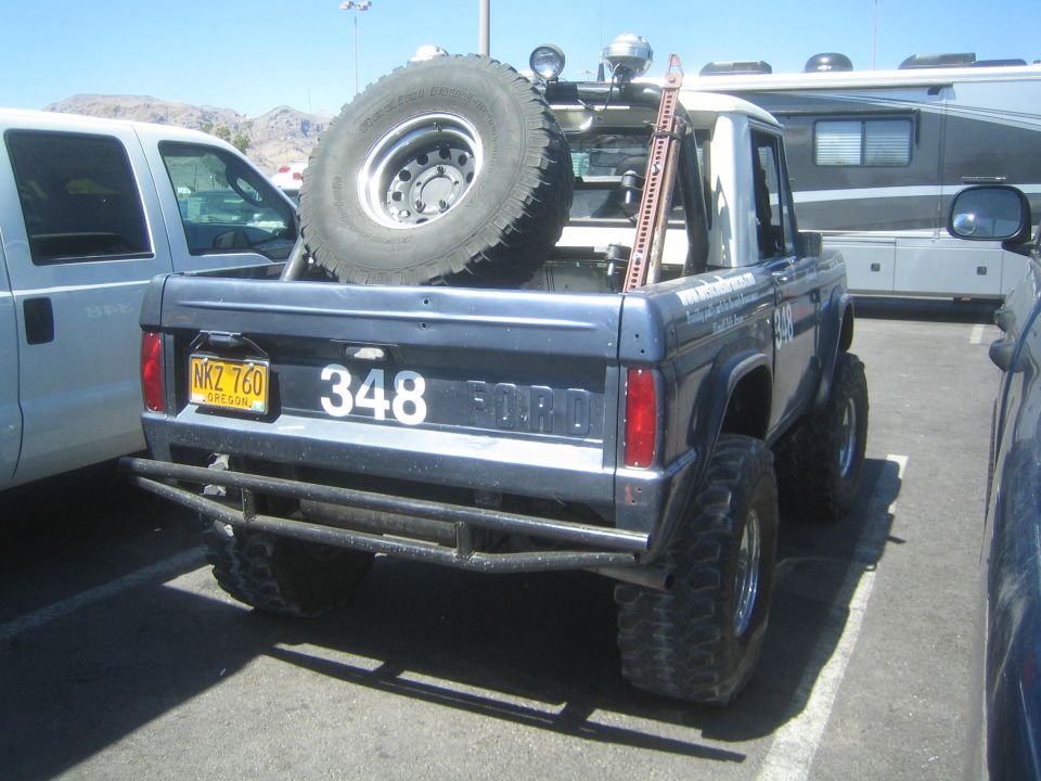 Rear three-quarter of dark blue early Ford Bronco #348 with spare tire and FORD badge