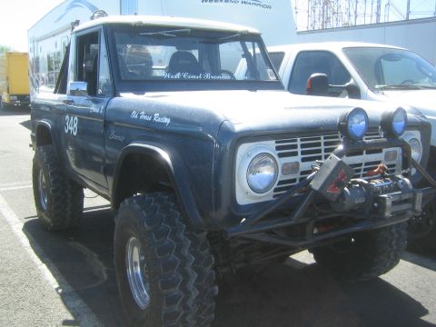 1990 Ford Bronco - Front quarter view of a lifted dark blue early Ford Bronco numbered 348, with a front winch and round driving lights.