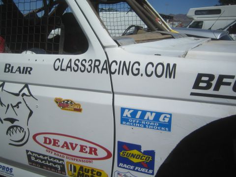 1990 Ford Bronco - Close-up of a white race truck's door panel showing CLASS3RACING.COM lettering plus Deaver, King and Sunoco sponsor decals.
