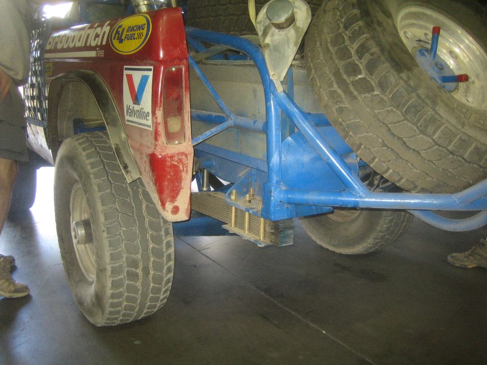 Front wheel, red fender and blue tube bumper of an off-road race truck with BFGoodrich and Valvoline decals