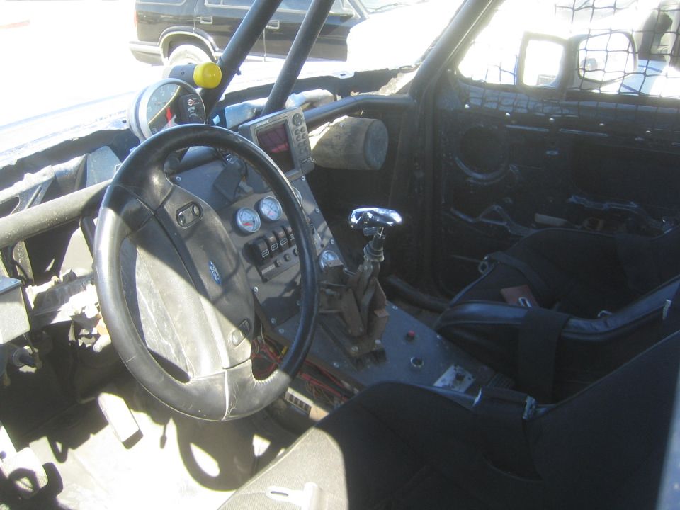 Stripped race truck interior with Ford steering wheel, gauges, shifter and bucket seat
