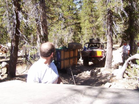 1967 Ford Bronco - Off-road vehicles navigate a challenging dirt trail through a wooded area.