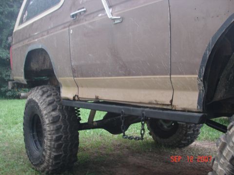 1987 Ford Bronco - This modified Ford Bronco features large tires and a lifted suspension, with a focus on its side profile and undercarriage.