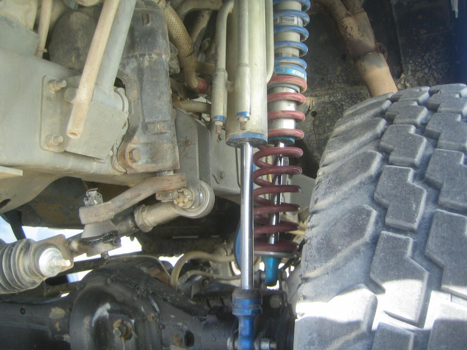 Front suspension with blue and red coilover, control arms and tie rod