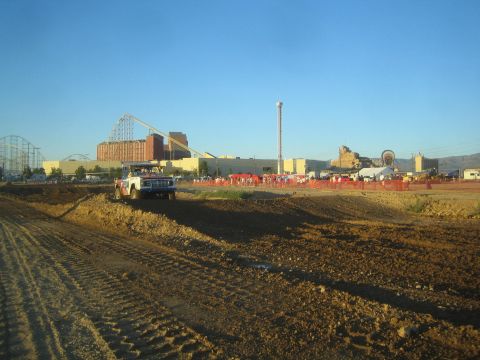 1990 Ford Bronco - off-road truck travels along a dirt short-course berm, with a crowd and amusement park rides in the background.