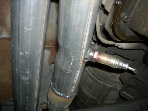 1996 Ford Bronco - Close-up of an exhaust system component, showing an oxygen sensor installed on a pipe.