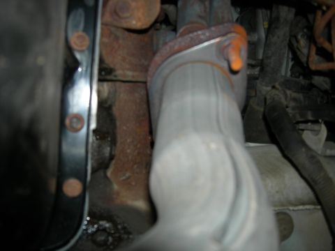 1996 Ford Bronco - This is a close-up view of a vehicle's exhaust system and surrounding engine components.