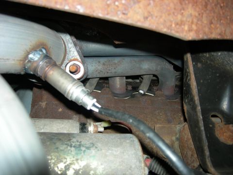 1996 Ford Bronco - Close-up view of an exhaust manifold and oxygen sensor, indicating wear and rust.