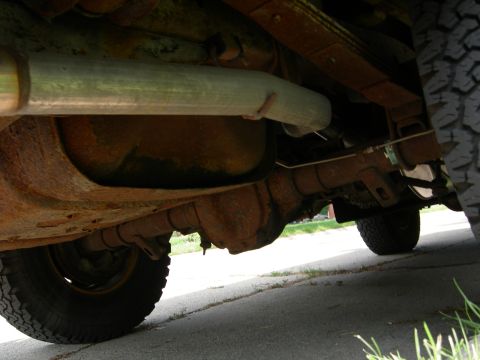 1996 Ford Bronco - Close-up view of the exhaust system and rear axle of a vehicle.