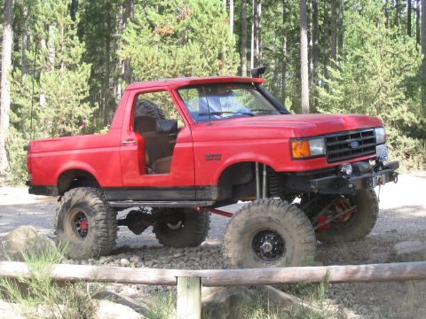 1989 Ford Bronco - This modified Ford Bronco features a lifted suspension, off-road tires, and a snorkel, indicating it is built for challenging terrain.