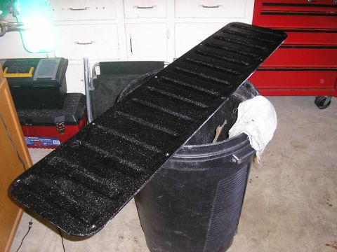 1996 Ford Bronco - A black textured tailgate panel is shown resting on a black bucket in a garage setting.