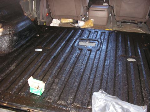 1996 Ford Bronco - Interior of a truck bed after applying a black spray-on liner.