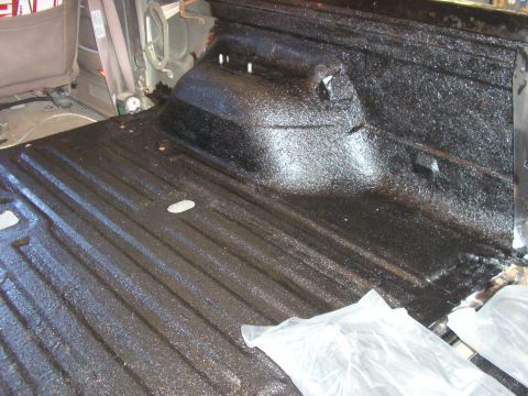 1996 Ford Bronco - The bed of a vehicle has been coated with a textured black spray-on liner.