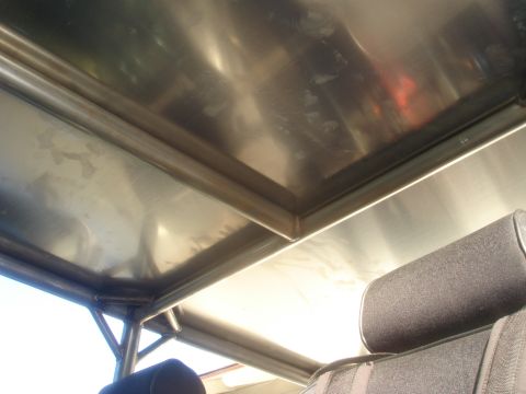 1977 Ford Bronco - Close-up of the interior roof structure and a headrest, with a watermark indicating 'SUPERMOTORS'.