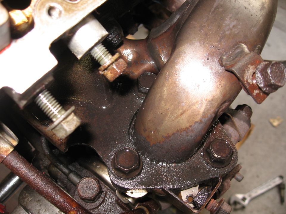 Engine exhaust manifold with oil leaks and rusty bolts