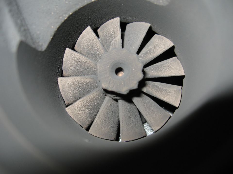 Close-up of a turbocharger compressor wheel with angled blades