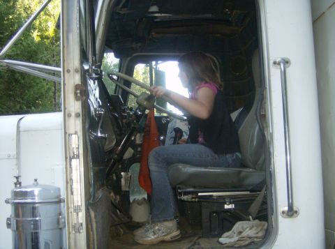 1986 Ford Bronco - A young girl pretends to drive a large truck from the interior of the cab.