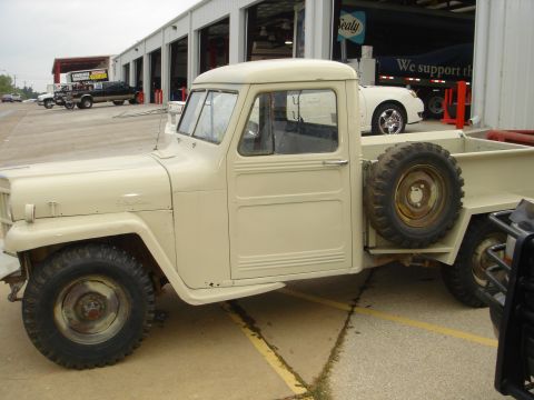1958 Jeep J-10 - This 1958 Jeep Willys pickup truck is seen from the side with its spare tire mounted externally.