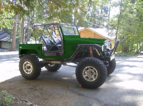 1989 Ford Bronco - This modified off-road vehicle is green with a roll cage and oversized tires.
