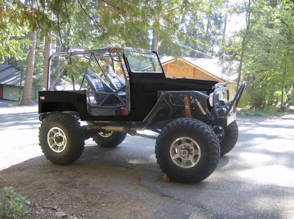 Black off-road vehicle with roll cage and large tires parked outdoors