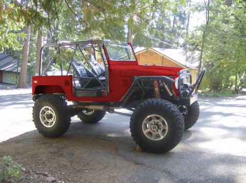 1989 Ford Bronco - Modified off-road vehicle with custom roll cage and suspension components parked outdoors.
