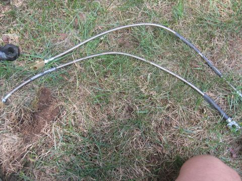 1996 Ford Bronco - Pair of brake lines with fittings on grass.