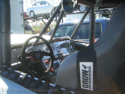 1990 Ford Bronco - Interior of an open off-road buggy showing a steering wheel, gauge cluster, roll cage and a Crow Enterprizes bucket seat.