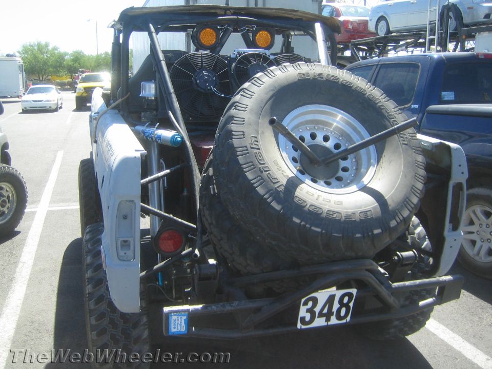 Rear of a white off-road Bronco rig with spare tire and number 348