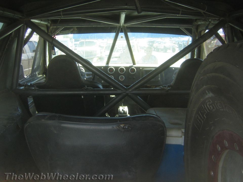 Interior roll-cage view of an off-road race vehicle with X-brace and bucket seat