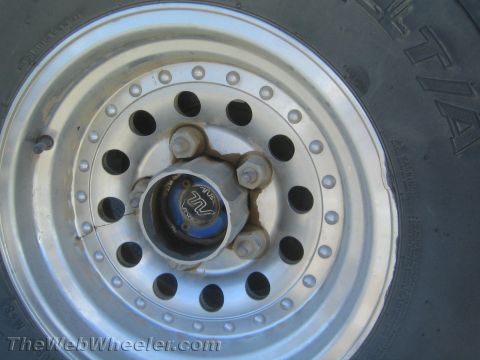 1990 Ford Bronco - Close-up of a silver steel off-road wheel mounted with a BFGoodrich tire and fitted with a blue Warn manual locking hub.