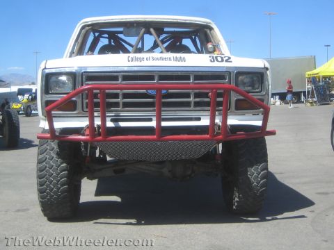 1990 Ford Bronco - Front view of a white Ford race truck numbered 302 lettered College of Southern Idaho, with a red tube bumper and roll cage.