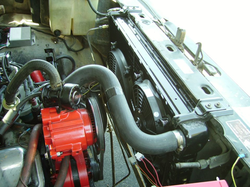 Engine bay with red alternator, black hoses and aluminum radiator