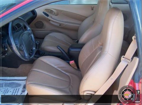 1996 Ford Probe - Interior view of a car with tan leather bucket seats and a steering wheel. Text on floor mat is partially visible.