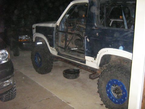 1986 Ford Bronco - This modified 1986 Ford Bronco features a roll cage and oversized off-road tires, suggesting it's built for terrain.