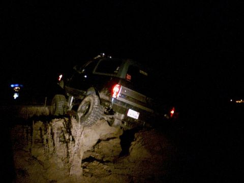 1996 Ford Bronco - This 1996 Ford Bronco is precariously positioned on a dirt embankment in the dark.