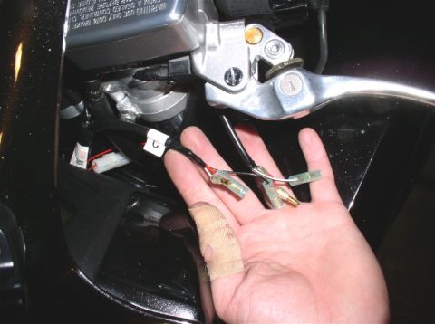 1990 Ford Bronco - Close-up of motorcycle brake lever assembly with exposed wiring connectors.