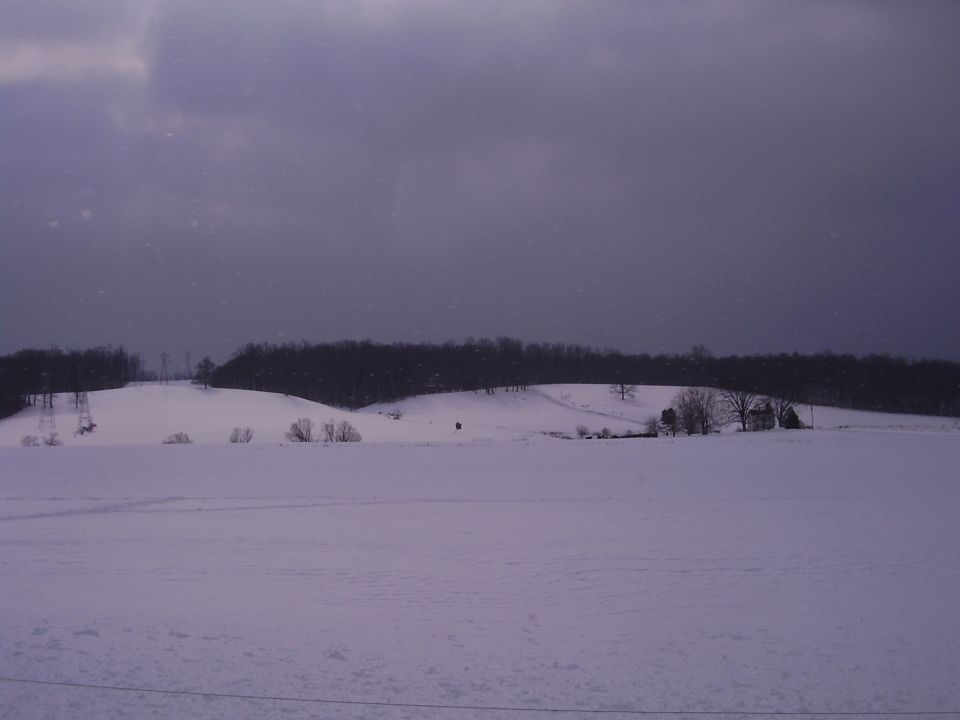 Snowy landscape with a distant figure and a Supermotors watermark
