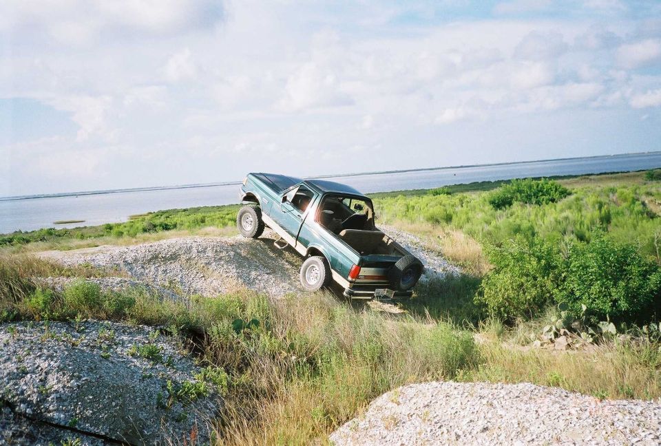 Ford pickup truck on a dirt hill near water
