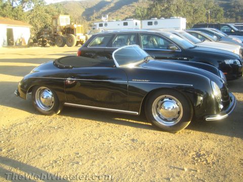 1990 Ford Bronco - black Porsche 356 Speedster-style roadster with chrome wheels is parked on dirt among other vehicles.