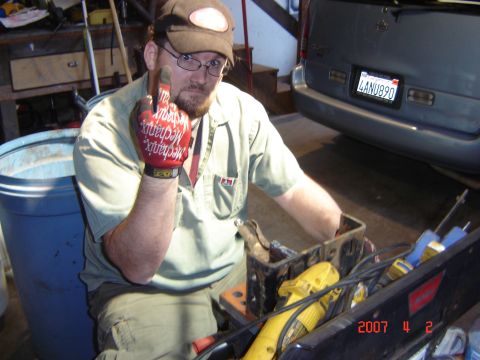 1993 Ford Bronco - Man in garage with tools and a parked SUV behind him.
