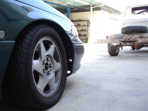1993 Ford Taurus - A green sedan is parked next to a trailer in what appears to be a workshop or garage.