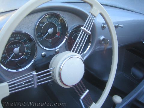 1990 Ford Bronco - Vintage instrument cluster with speedometer reading 00036 km behind a cream three-spoke steering wheel.